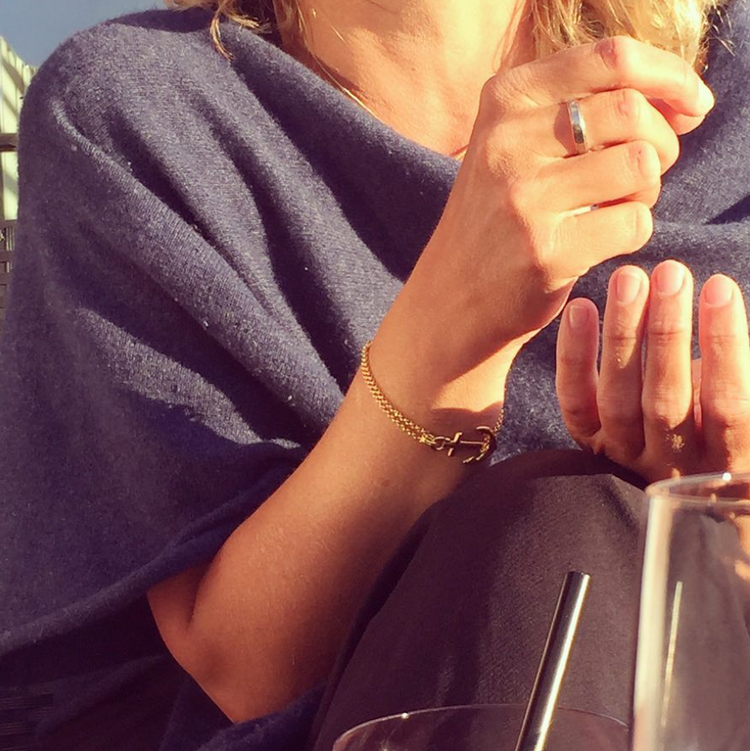 Gold anchor chain bracelet on a wrist in the evening sun