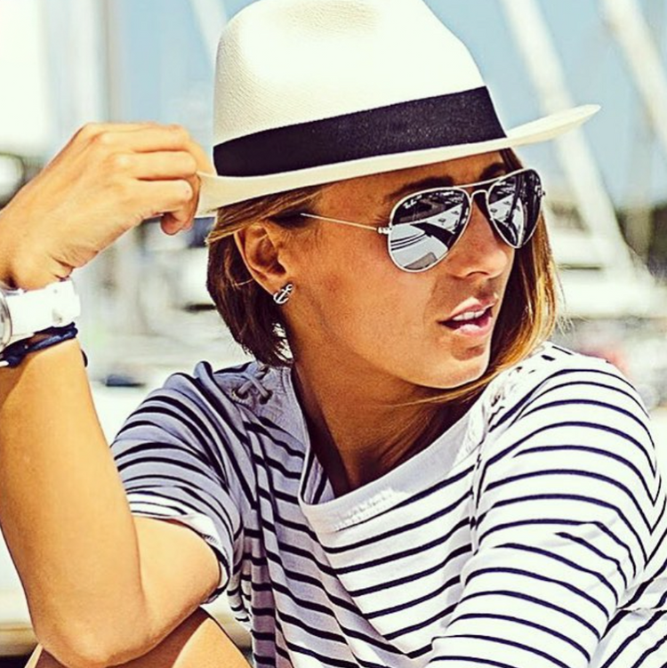 Woman in a sun hat and striped top wearing anchor earrings